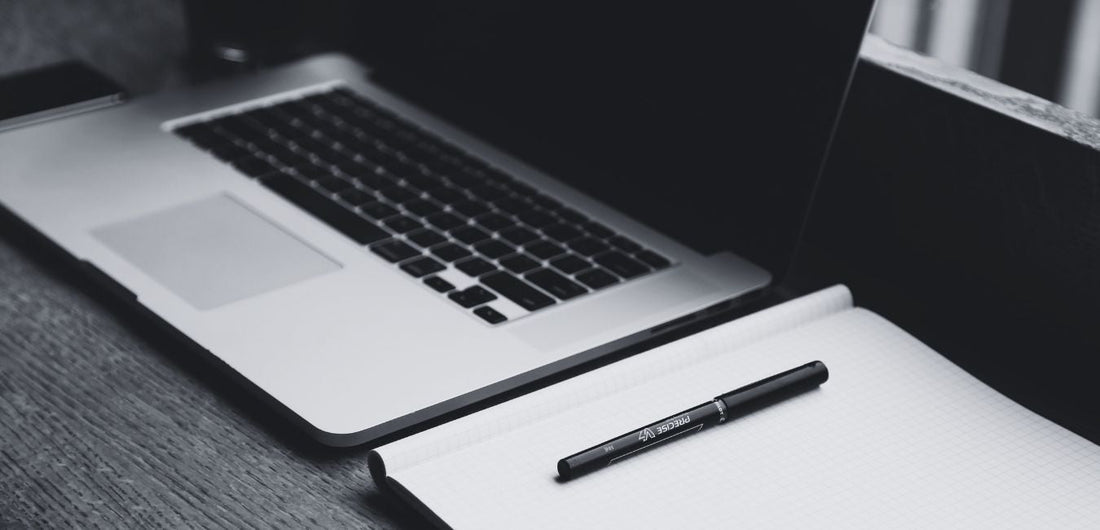the hardest thing about writing - black and white image of laptop, notebook and pen on desk